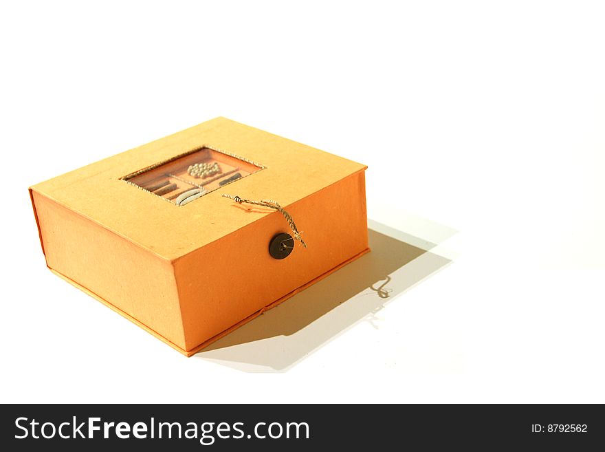 An orange decorative box with button on the front side and decor on the top. An orange decorative box with button on the front side and decor on the top.