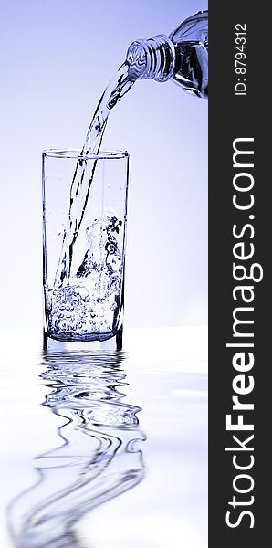 Water flowing from a bottle in a glass. Studio shooting. Water flowing from a bottle in a glass. Studio shooting.