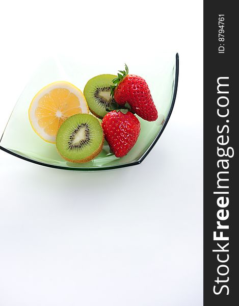 Kiwi, strawberry and lime on green bowl. Kiwi, strawberry and lime on green bowl