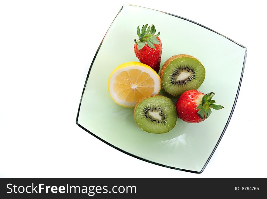 Kiwi, strawberry and lime on green bowl. Kiwi, strawberry and lime on green bowl