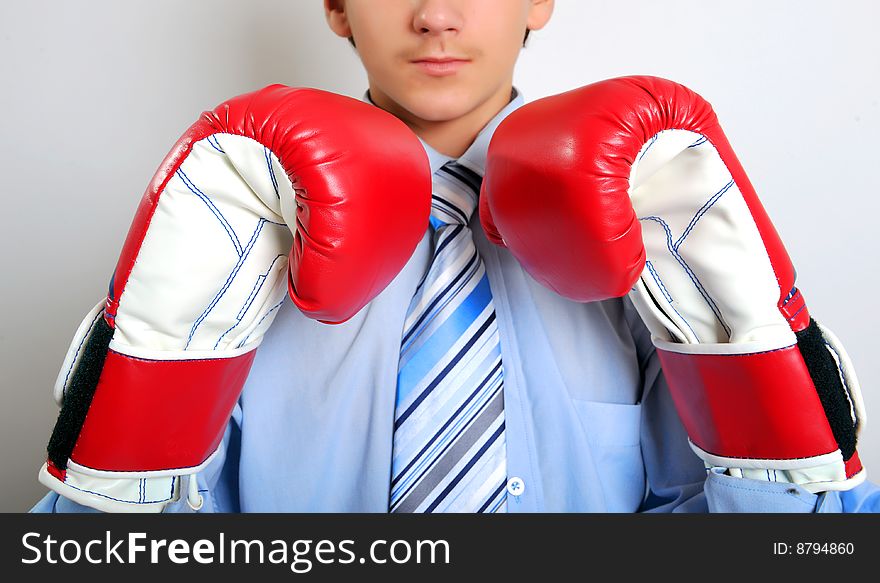 Young businessman wearing boxing gloves. Young businessman wearing boxing gloves