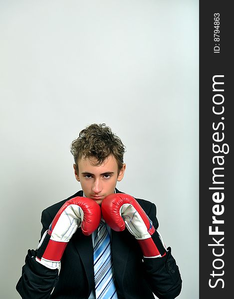 Young businessman wearing boxing gloves. Young businessman wearing boxing gloves