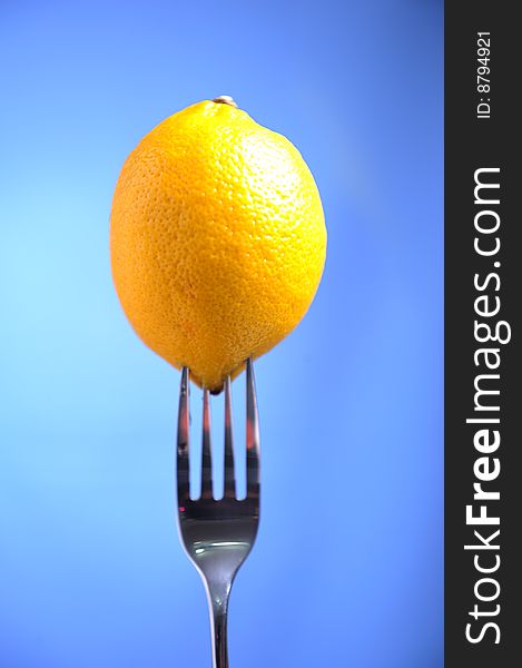 Lime in a fork on blue backgound