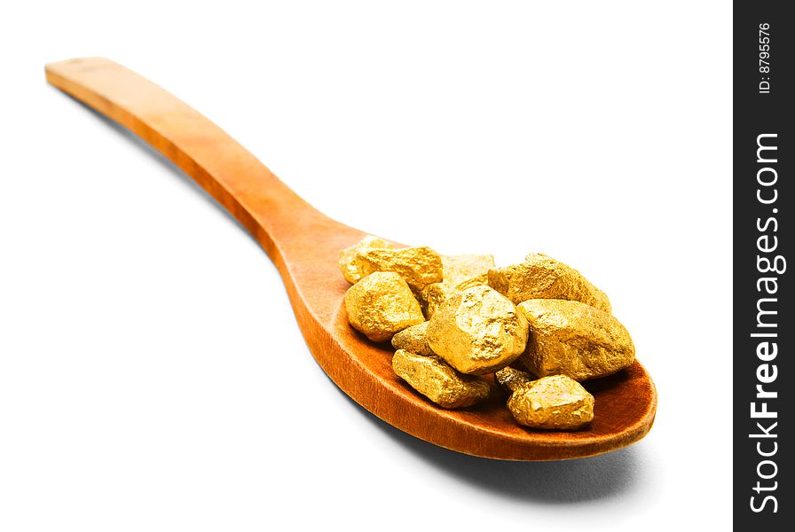 Gold pieces in a wooden spoon isolated over white