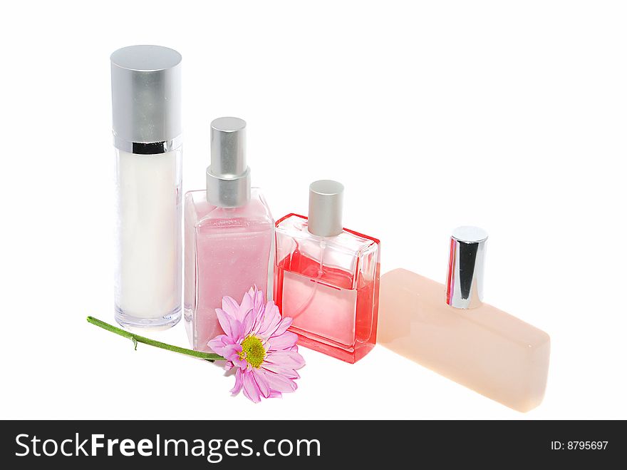 Some perfume bottles with pink flower isolated on white. Some perfume bottles with pink flower isolated on white.