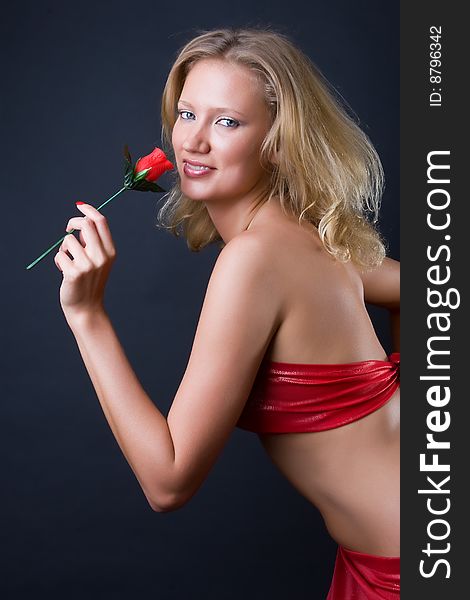 Beautiful girl with a flower in hands against a dark background. Beautiful girl with a flower in hands against a dark background