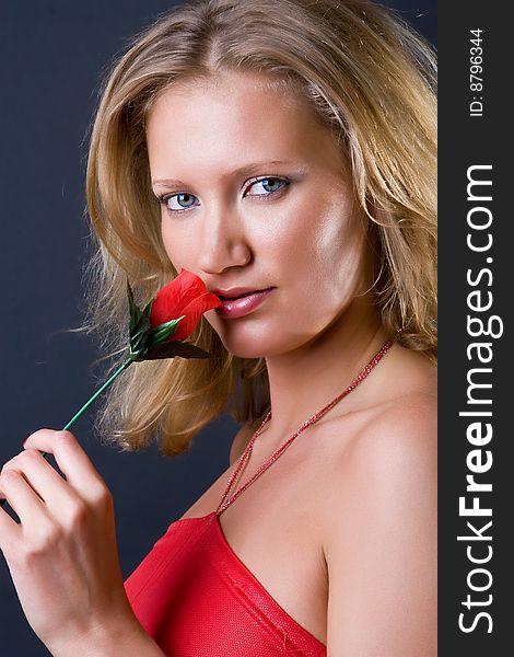 Beautiful girl with a flower in hands against a dark background