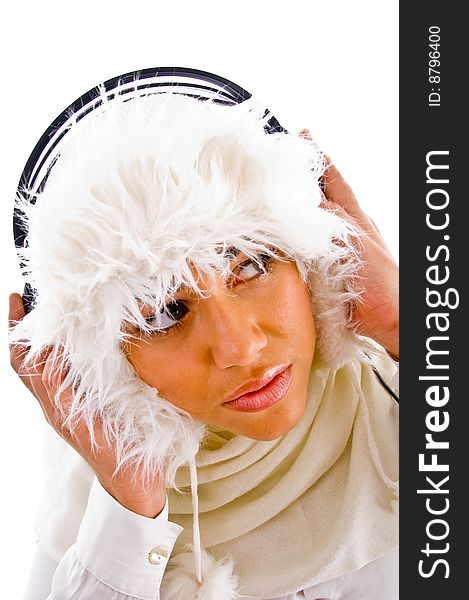 Woman holding headphone and looking upward against white background