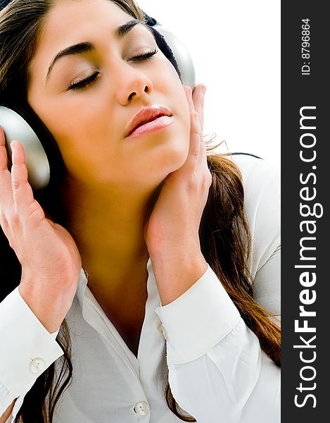 Young girl listening light music with closed eyes on an isolated background