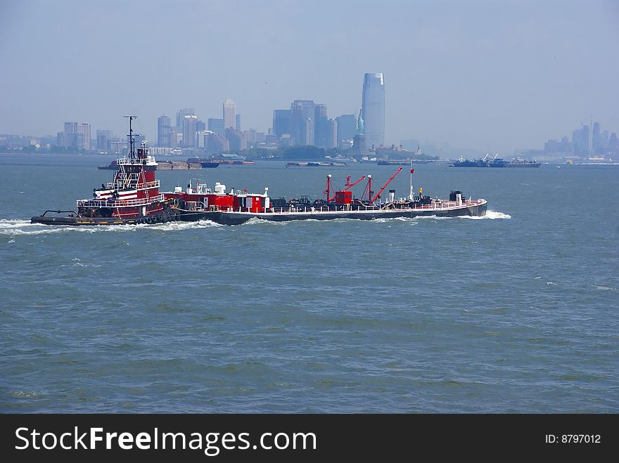 Tugboat pushing barge in New York Harbor, from Staten Island Ferry, New York City