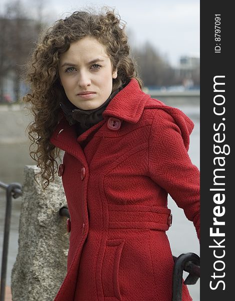 Teenage girl in Poland, portrait. Young girl with curly hairs wearing red coat, posing in Wroclaw city.