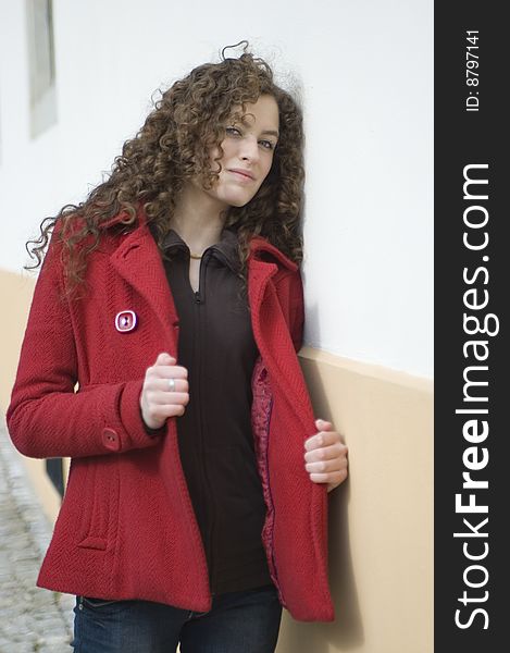 Teenage girl in Poland, portrait. Young girl with curly hairs wearing red coat, posing in Wroclaw city. Teenage girl in Poland, portrait. Young girl with curly hairs wearing red coat, posing in Wroclaw city.