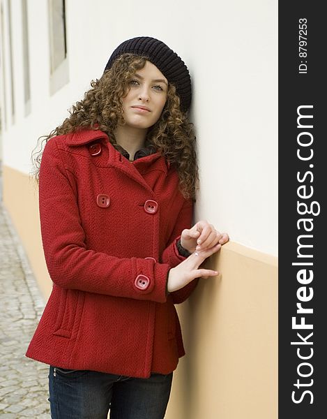 Teenage girl in Poland, portrait. Young girl with curly hairs wearing red coat, posing in Wroclaw city. Teenage girl in Poland, portrait. Young girl with curly hairs wearing red coat, posing in Wroclaw city.