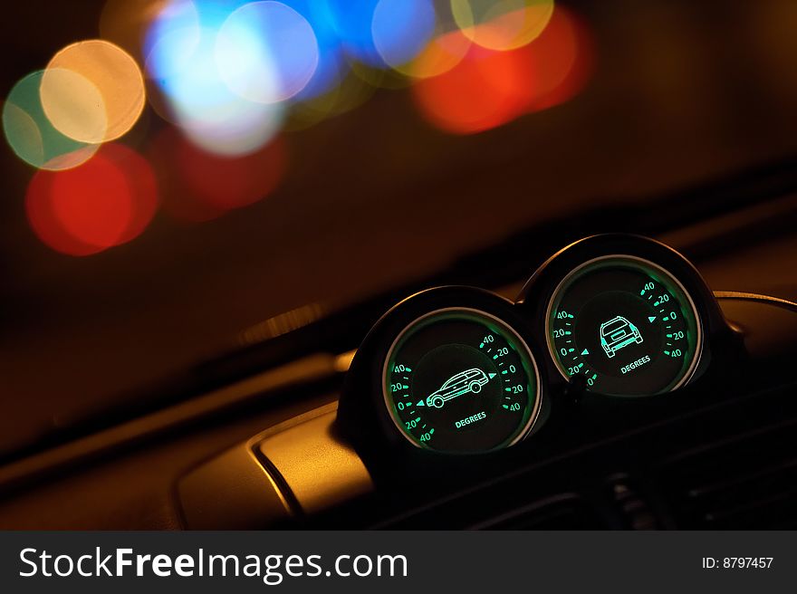 Night shot of vehicle's dashboard with instruments and out of focus background lights. Night shot of vehicle's dashboard with instruments and out of focus background lights.