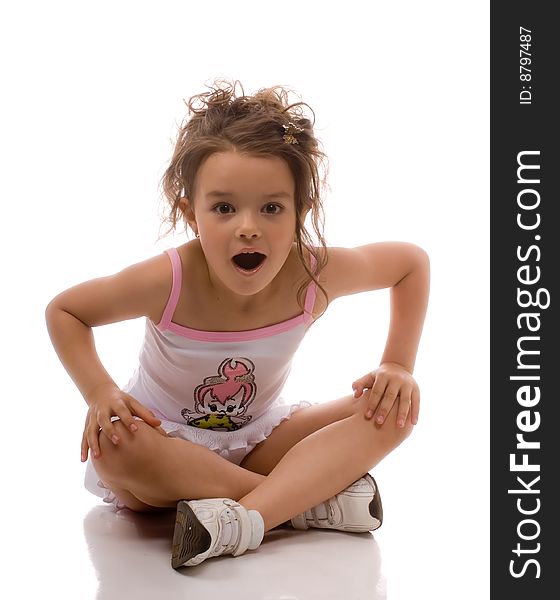 The little girl in a white dress sitting on the floor. The little girl in a white dress sitting on the floor