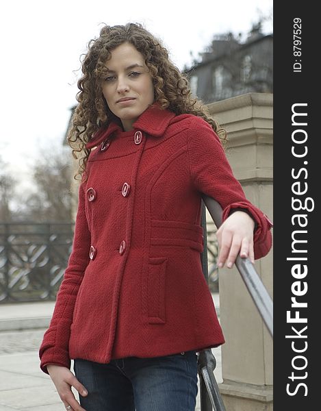 Teenage girl in Poland, portrait. Young girl with curly hairs wearing red coat, posing in Wroclaw city.