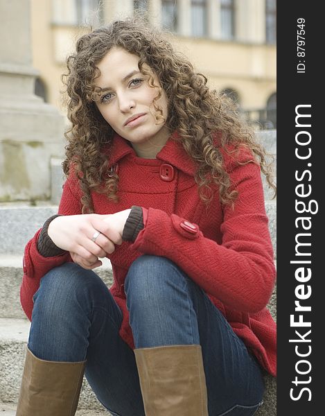 Teenage girl in Poland, portrait. Young girl with curly hairs wearing red coat, posing in Wroclaw city. Teenage girl in Poland, portrait. Young girl with curly hairs wearing red coat, posing in Wroclaw city.