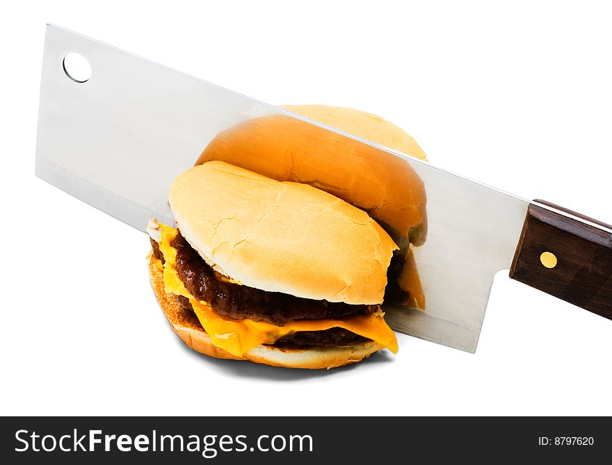 Meat cleaver cutting a burger isolated over white