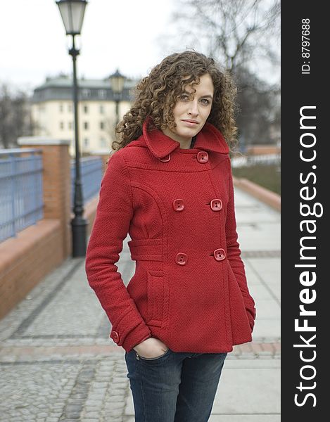 Teenage girl in Poland, portrait. Young girl with curly hairs wearing red coat, posing in Wroclaw city. Teenage girl in Poland, portrait. Young girl with curly hairs wearing red coat, posing in Wroclaw city.