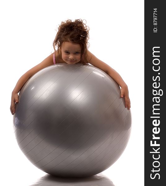 A little girl lying on a big gray ball. A little girl lying on a big gray ball
