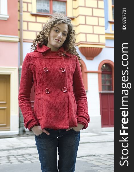 Teenage girl in Poland, portrait. Young girl with curly hairs wearing red coat, posing in Wroclaw city.