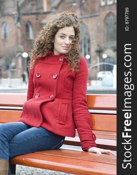 Teenage girl in Poland, portrait. Young girl with curly hairs wearing red coat, posing in Wroclaw city. Teenage girl in Poland, portrait. Young girl with curly hairs wearing red coat, posing in Wroclaw city.