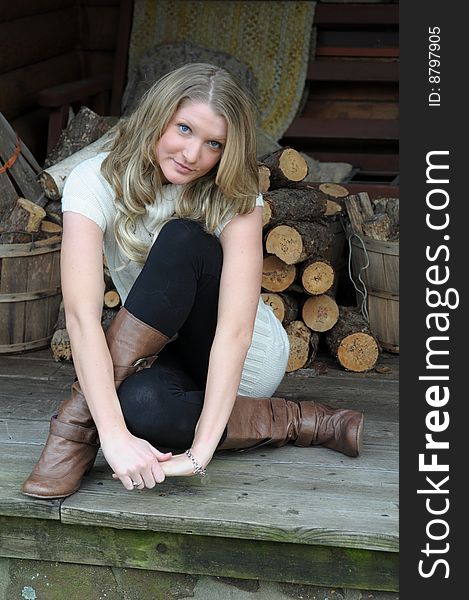 Attractive blond teen in front of log cabin. Attractive blond teen in front of log cabin
