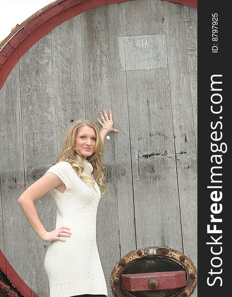 Attractive bond teen walking in sweater with barrel in background. Attractive bond teen walking in sweater with barrel in background