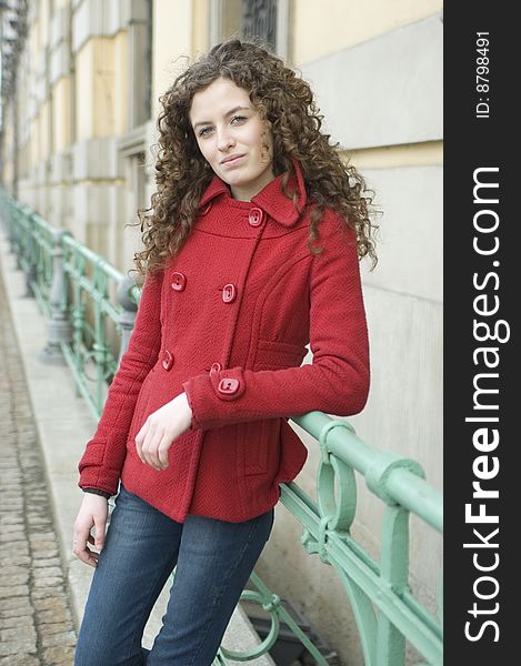 Teenage girl in Poland, portrait. Young girl with curly hairs wearing red coat,