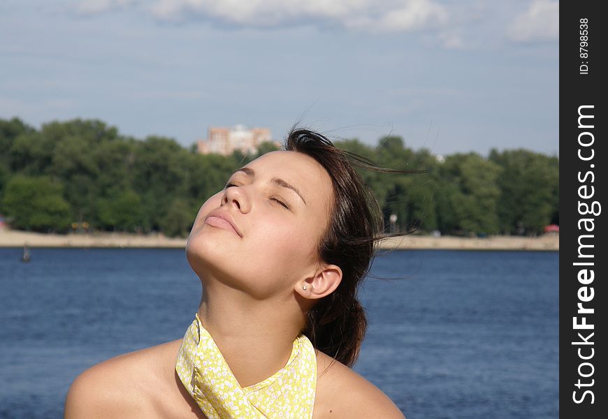 Girl on a background the river and forest against wind