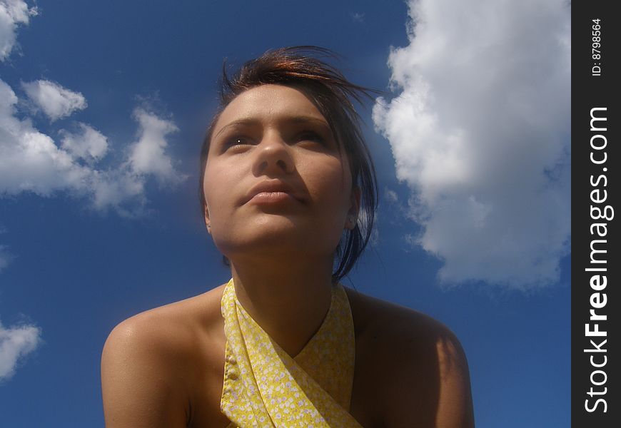 Look of girl forward on a background blue sky against wind