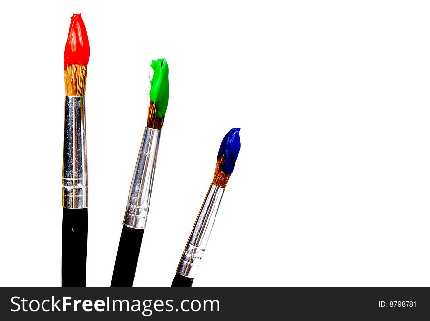 Several paintbrushes with colored paint: red, blue, green, yellow, white and black