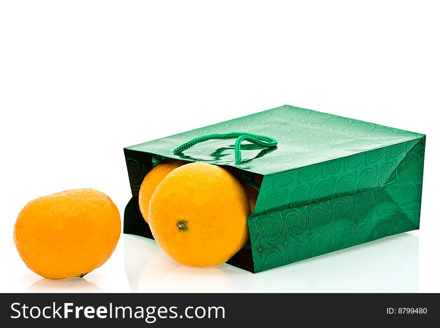 Green package and mandarines on a white background