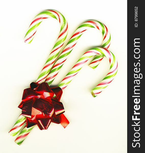 Three candy canes with red bow on white background isolated, Christmas background