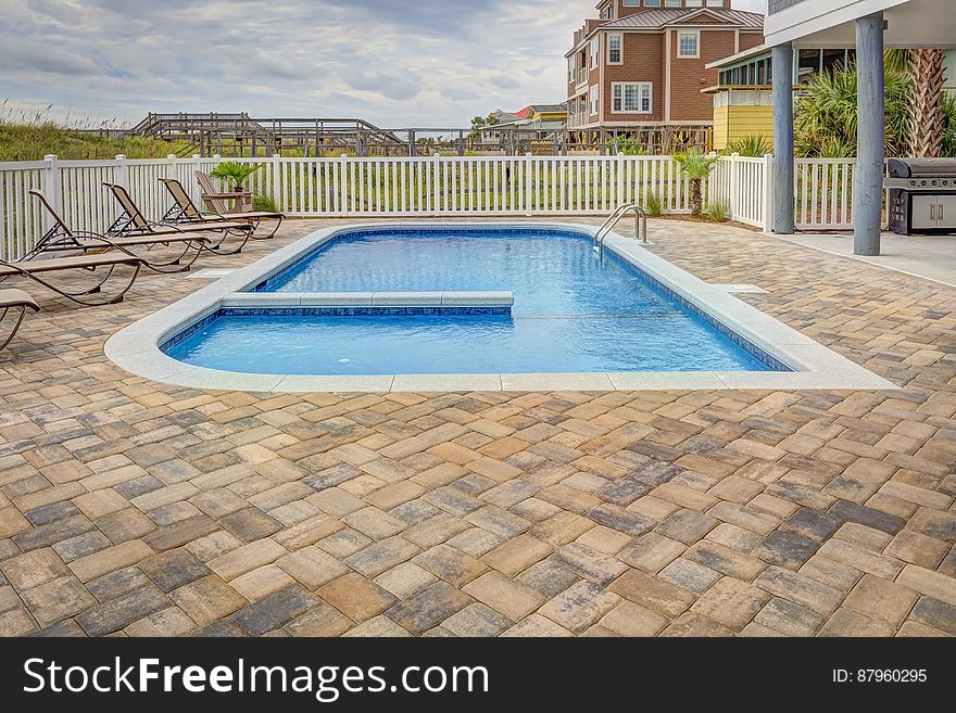 A blue swimming pool on the yard of a house. A blue swimming pool on the yard of a house.