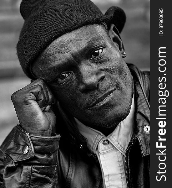 Close up portrait of African man in leather jacket and knit beanie in black and white. Close up portrait of African man in leather jacket and knit beanie in black and white.