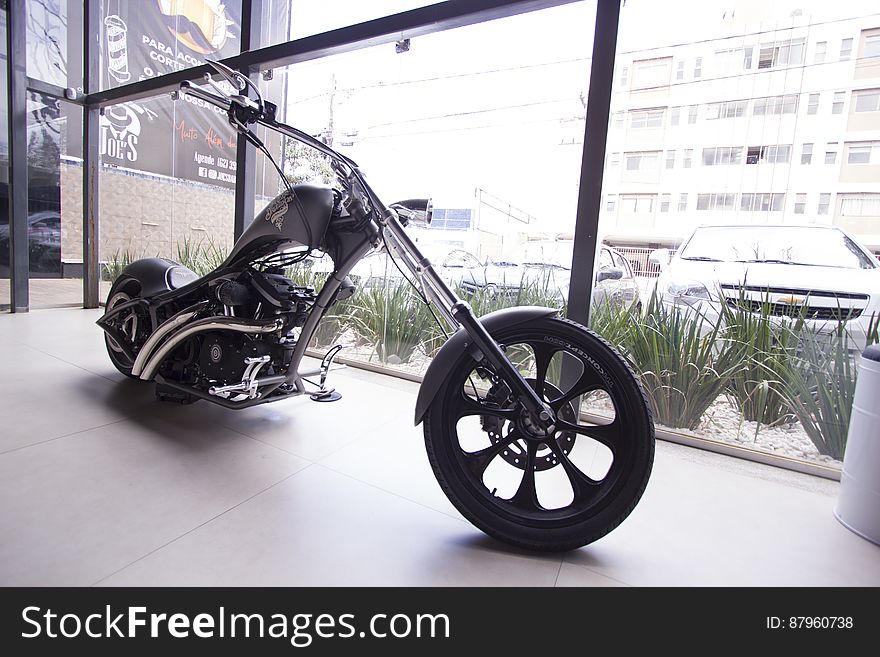 Modern motorbike inside showroom against window in city. Modern motorbike inside showroom against window in city.