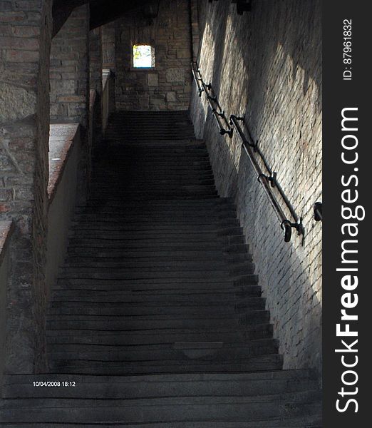 A steep flight of stairs inside a stone building.