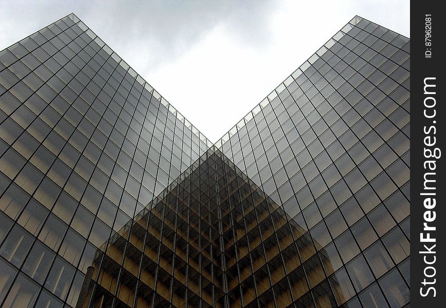 Two identical modern office buildings with glass facades.
