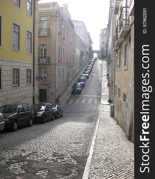 A view of a street with cars parked to the side. A view of a street with cars parked to the side.