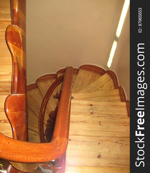 View looking down a curved wooden staircase in a home.