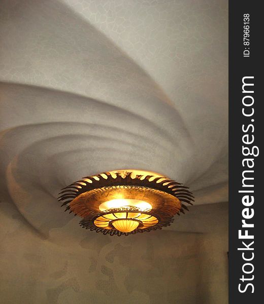A luxurious round chandelier on ceiling relief. A luxurious round chandelier on ceiling relief.