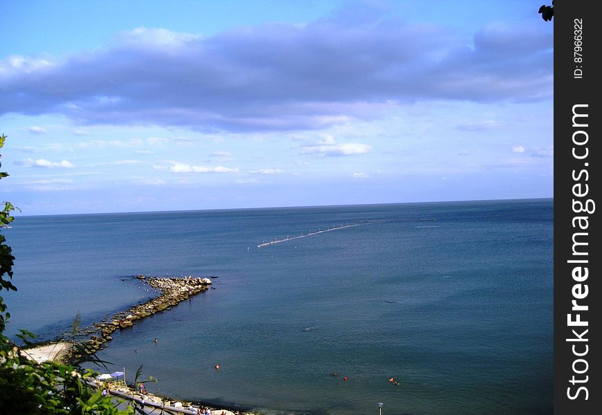 A panoramic view of a beach and open sea in the background.