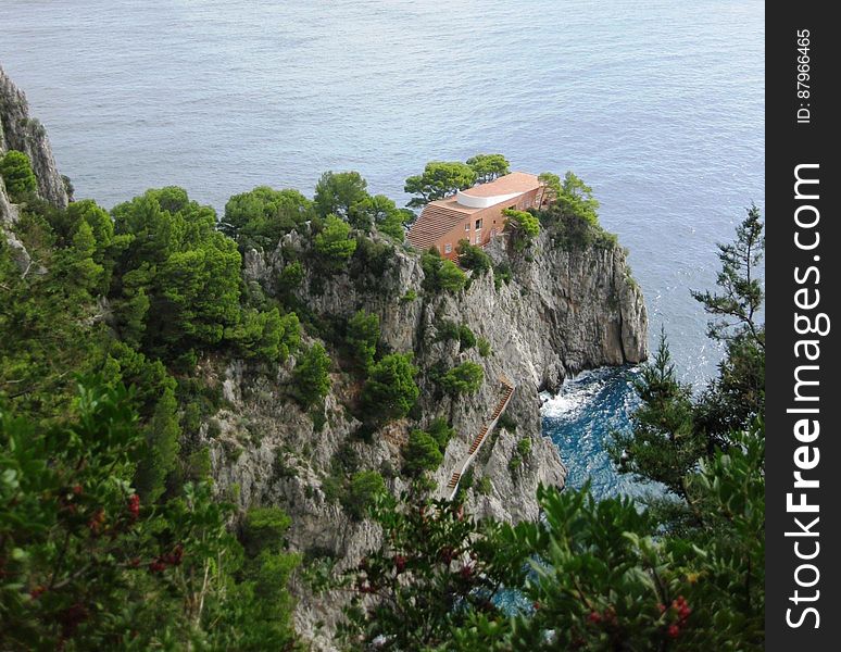 A view of a house on a sea cliff and the sea in the background. A view of a house on a sea cliff and the sea in the background.