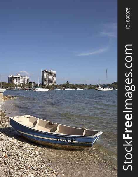 Small wooden boat on the shoreline of island park with the skyline of sarasota in the background florida united states taken in march 2006