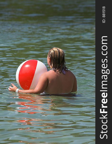 Girl playing in water at local lake with beach ball. Girl playing in water at local lake with beach ball