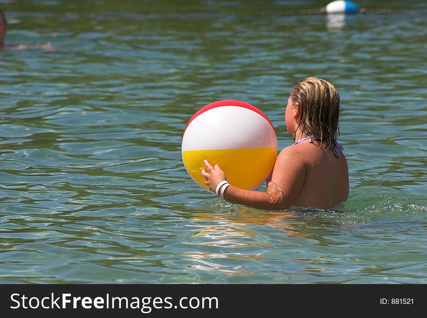 Little girl playing in water with beach ball. Little girl playing in water with beach ball