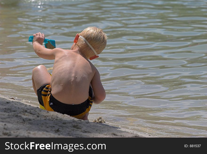 Child swimming & playing in the sand at local lake in Florida. Child swimming & playing in the sand at local lake in Florida