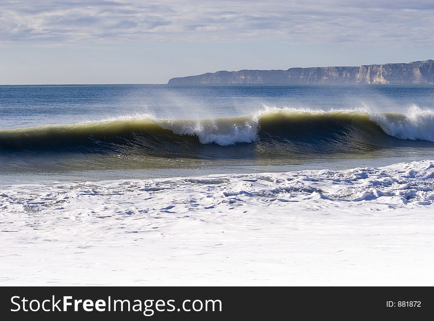 Waves breaking with Cape Kidnappers in Background. Hawke's Bay, New Zealand