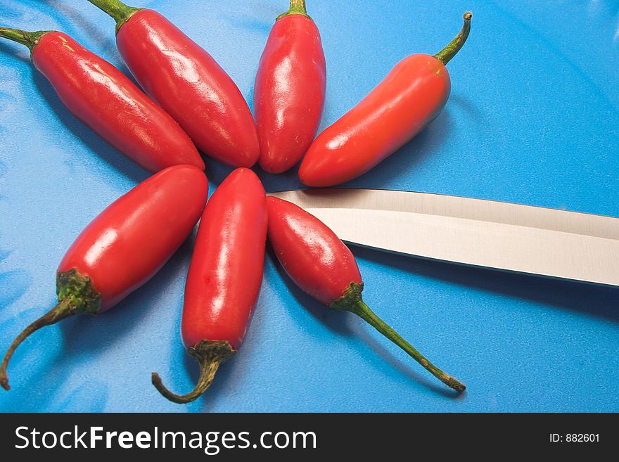 Red Chillies with steak knife and blue